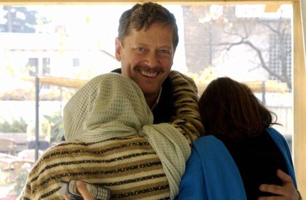 British television cameraman Peter Jouvenal (C) smiles as he is reunited with his wife (R) and sister-in-law (L) in Kabul, Afghanistan, on Nov. 26, 2004, after being released from questioning by Afghan authorities. (Farzana Wahidy/AFP via Getty Images)