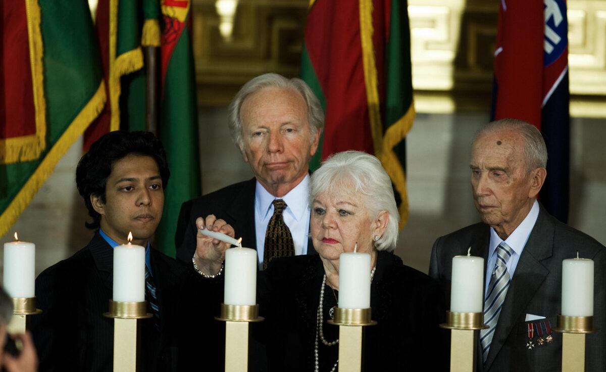  Sen. Joseph Lieberman (rear) (I-Conn.), looks on as Etta Katz lights a memorial candle and Jozef Walaszczyk (R) looks on during the National Holocaust Museum Days of Remembrance Ceremony in the Rotunda of the US Capitol in Washington on Apr. 23, 2009. (Paul J. Richards/AFP via Getty Images)