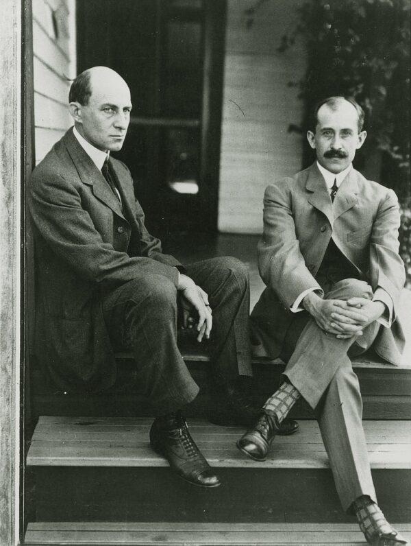 Wilbur (L) and Orville Wright sit on the porch steps of their Dayton, Ohio, home, June 1909. (Public Domain)