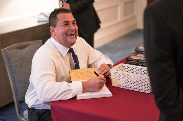 Adams signs one of his best- selling books. (Tex Fischer / H&F Strategies)