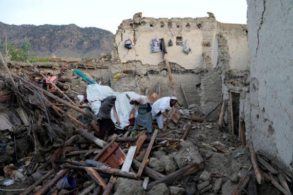 Afghans stand among destruction after an earthquake in Gayan village, in Paktika province, Afghanistan, on June 23, 2022. (Ebrahim Nooroozi/AP Photo)