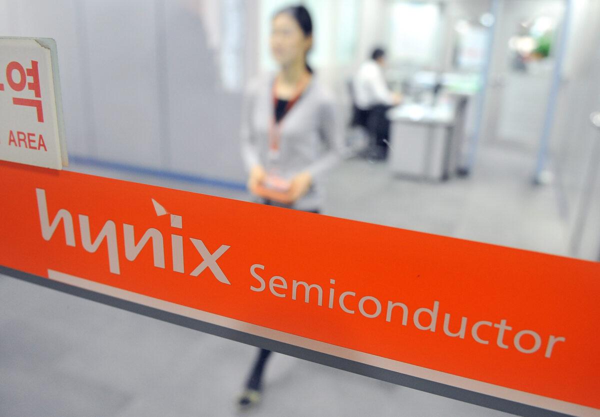 A South Korean employee of Hynix Semiconductor walks past a logo of the company at a branch in Seoul on Jan. 21, 2010. (Jung Yeon-Je /AFP via Getty Images)