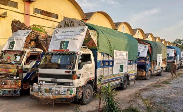 A convoy of trucks carrying relief goods including tents, blankets, and emergency medicines for Afghanistan's earthquake hit areas, prepare to leave for Afghanistan at a warehouse in Islamabad, Pakistan, on June 23, 2022. (National Disaster Management Authority via AP)