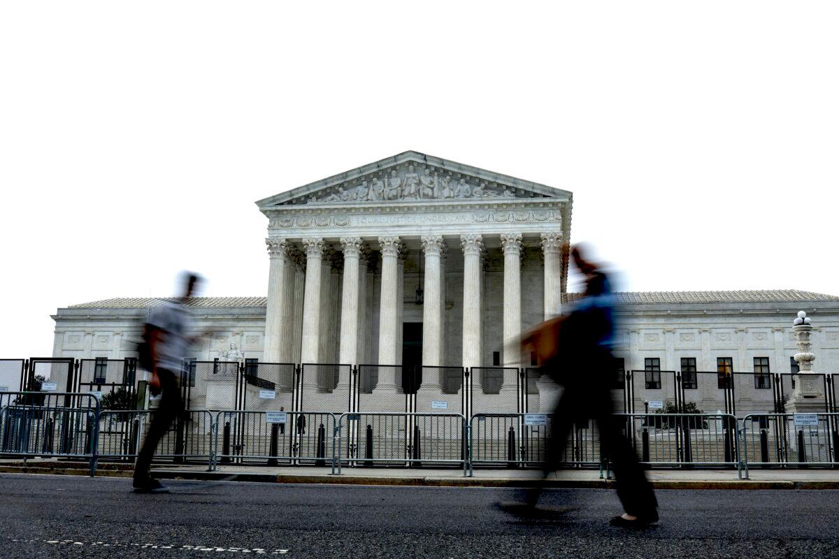 People walk past the Supreme Court building during a rainstorm in Washington on June 23, 2022. (Anna Moneymaker/Getty Images)