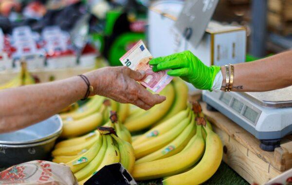 A shopper pays with a ten Euro banknote at a local market in Nice, France, on June 7, 2022. (Eric Gaillard/Reuters)