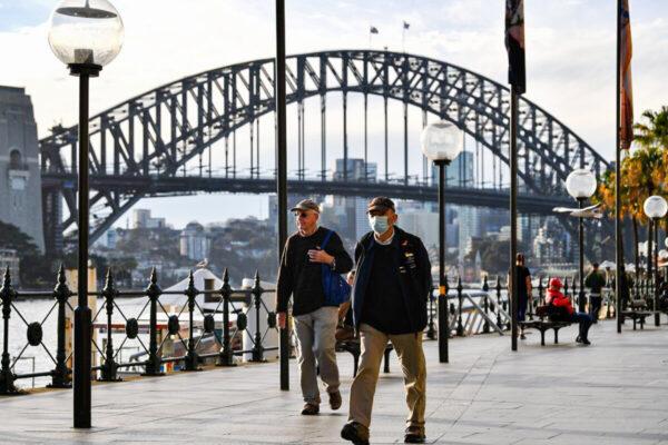 A man wearing a face mask walks before the Harbour Bridge in Sydney, NSW, Australia, on July 22, 2020. (Saeed Khan/AFP via Getty Images)