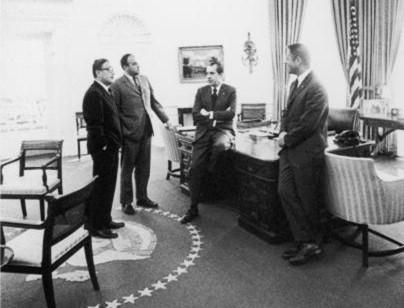  President Richard Nixon sits on desk while conferring with (L–R) National Security Adviser Henry Kissinger, General Counsel John Ehrlichman, and White House Chief of Staff H.R. Haldeman, circa 1970s. (Fotosearch/Getty Images)