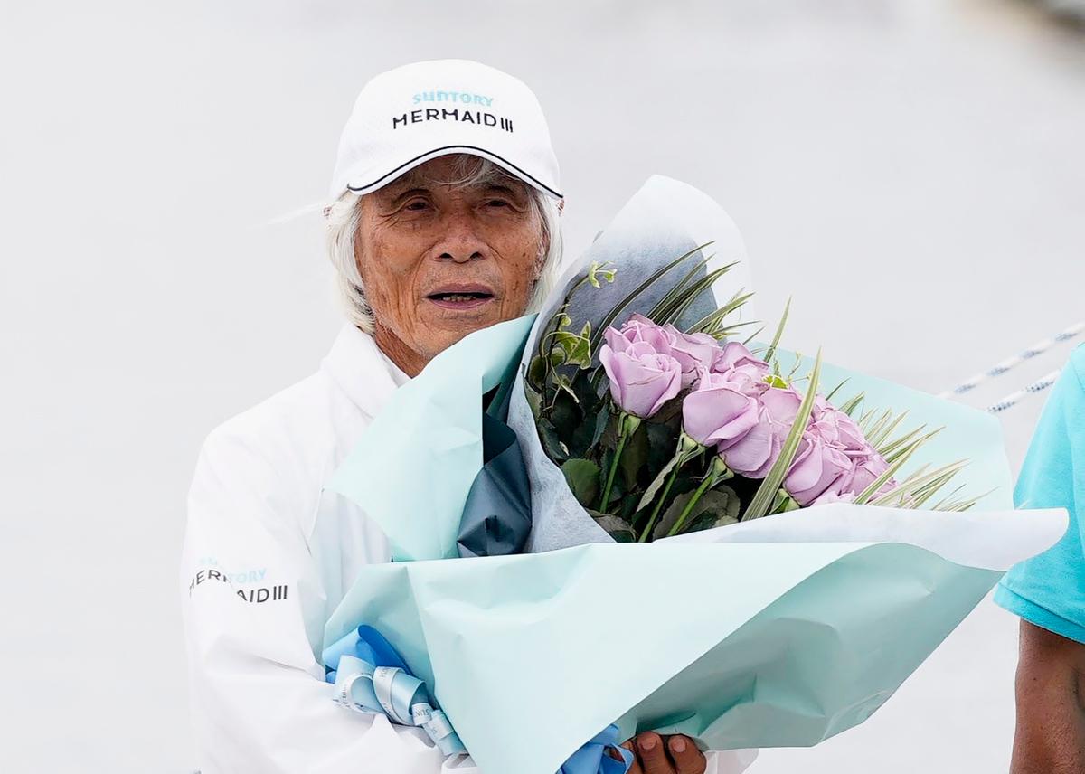 Horie receives a bouquet in celebration at a yacht harbor in Nishinomiya, western Japan, Sunday, June 5, 2022. (Ichiro Sakano/Kyodo News via AP)