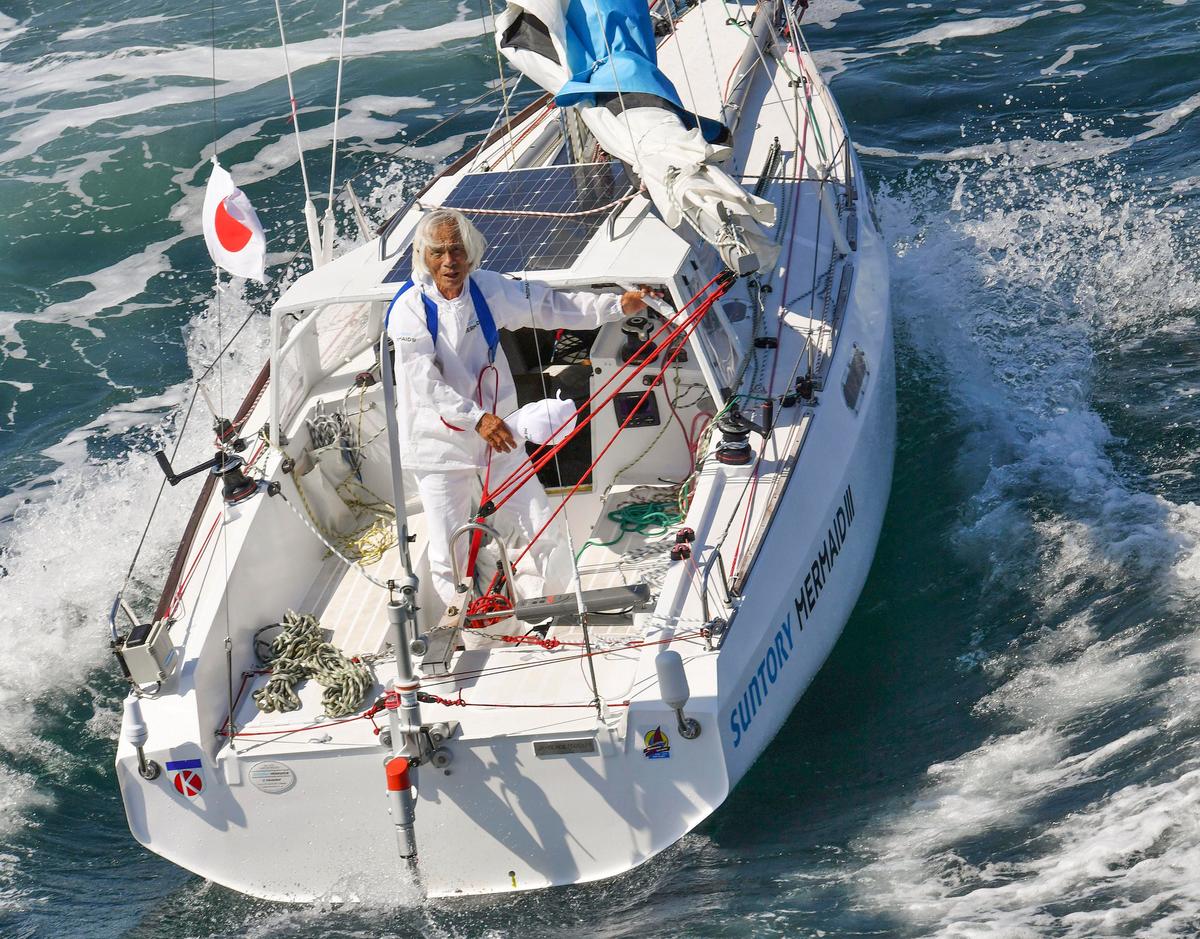 Japan's Kenichi Horie waves on his sailboat at Osaka Bay, western Japan, June 4, 2022, after his trans-Pacific voyage. (Kyodo News via AP)