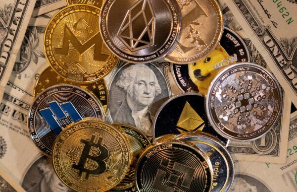 Representations of virtual cryptocurrencies are placed on U.S. dollar banknotes in this illustration taken on Nov. 28, 2021. (Dado Ruvic/Reuters)