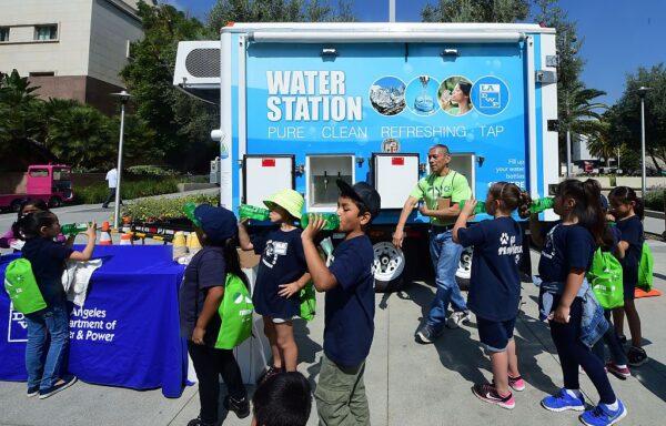 Elementary school children have a water break during a field trip to the Grand Park Earth Day celebration in downtown Los Angeles on April 22, 2016.<br/>(Frederic J. Brown/AFP via Getty Images)