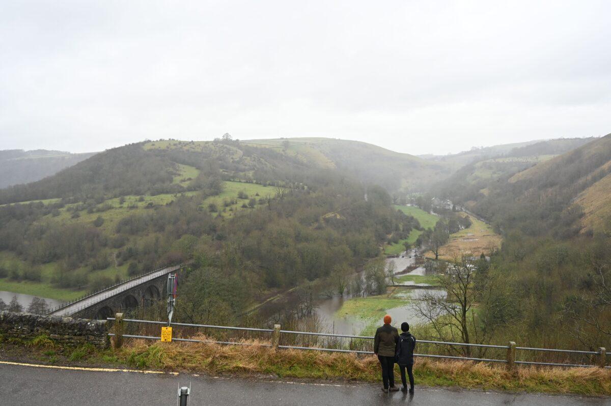 A couple look out over the Monsal valley as the river Wye has burst its banks near Great Longstone, northwest England, on Jan. 20, 2021. (Paul Ellis/AFP via Getty Images)