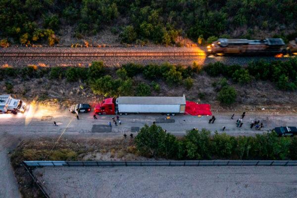 Law enforcement officers investigate a tractor-trailer carrying illegal immigrants, including dozens who died, in San Antonio on June 27, 2022. (Jordan Vonderhaar/Getty Images)