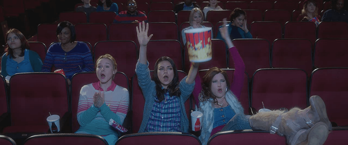 (L–R) Kiki (Kristen Bell), Amy (Mila Kunis), and Carla (Kathryn Hahn) behave badly in a movie theater, in “Bad Moms” (STX Productions)