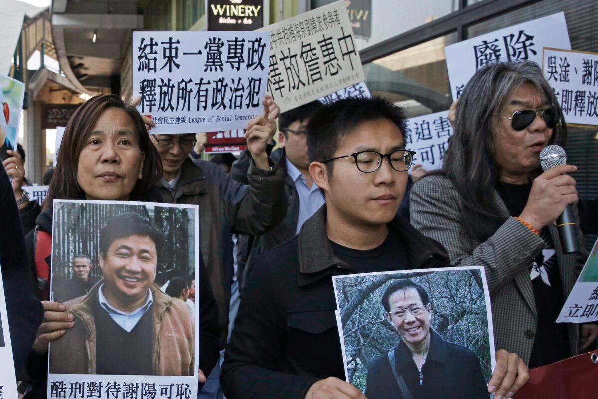 Chan Po-ying, a 66-year-old veteran pro-democracy activist(L), and her long-time partner and fellow activist Leung Kwok-hung(R), hold pictures of detained Chinese human rights activists outside the Chinese liaison office in Hong Kong on Dec. 27, 2017. (Kin Cheung/AP Photo)