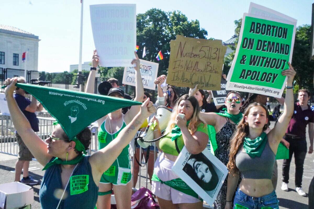 Pro-abortion protesters with Rise Up 4 Abortion Rights wear green as they protest outside the U.S. Supreme Court in Washington on June 15, 2022. (Jackson Elliott/The Epoch Times)
