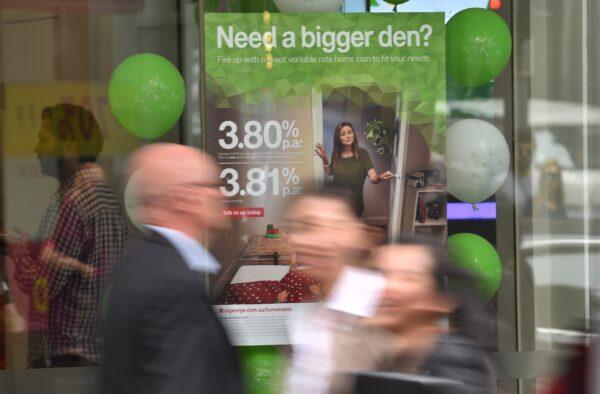 Pedestrians pass a bank advertising interest rates on mortgages in Sydney, Australia, on Oct. 3, 2017. (Peter Parks/AFP via Getty Images)
