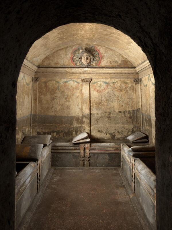 The most elaborate burial chamber of the Ipogeo dei Cristallini is decorated like a luxury room with Greek architecture, frescoes, "comfy" stone pillows, and a sculptural relief of the Gorgon Medusa. (Luciano and Marco Pedicini)