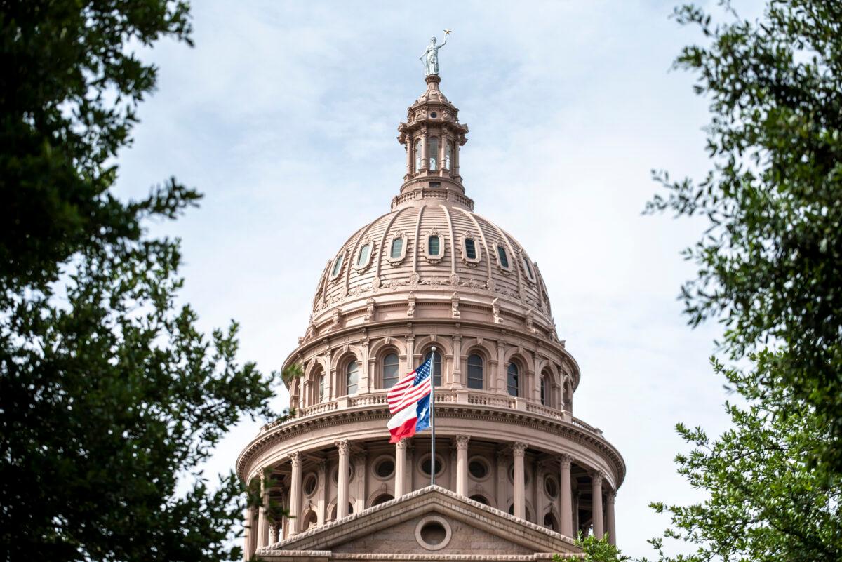 The United States and Texas state flags fly outside the state Capitol building in Austin, Texas, on July 12, 2021. (Sergio Flores/Getty Images)