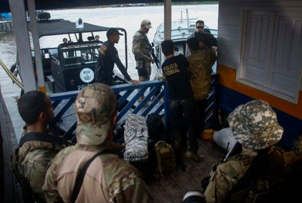 Federal police officers arrive at the pier with items found during a search for Indigenous expert Bruno Pereira and freelance British journalist Dom Phillips in Atalaia do Norte, Amazonas state, Brazil, on June 12, 2022. (Edmar Barros/AP Photo)