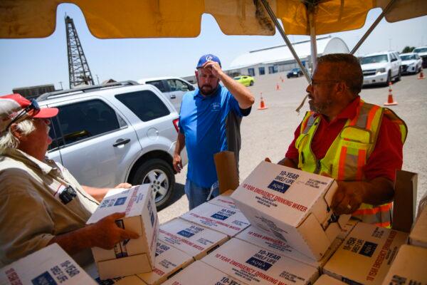 Volunteers begin to hand out 12-liter boxes of emergency drinking water to residents in need in Odessa, Texas, on June 14, 2022. (Eli Hartman/Odessa American via AP)
