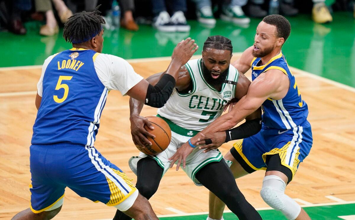 Boston Celtics guard Jaylen Brown (7) drives against Golden State Warriors guard Stephen Curry (30) and center Kevon Looney (5) during the first quarter of Game 6 of basketball's NBA Finals in Boston on June 16, 2022. (Steven Senne/AP Photo)