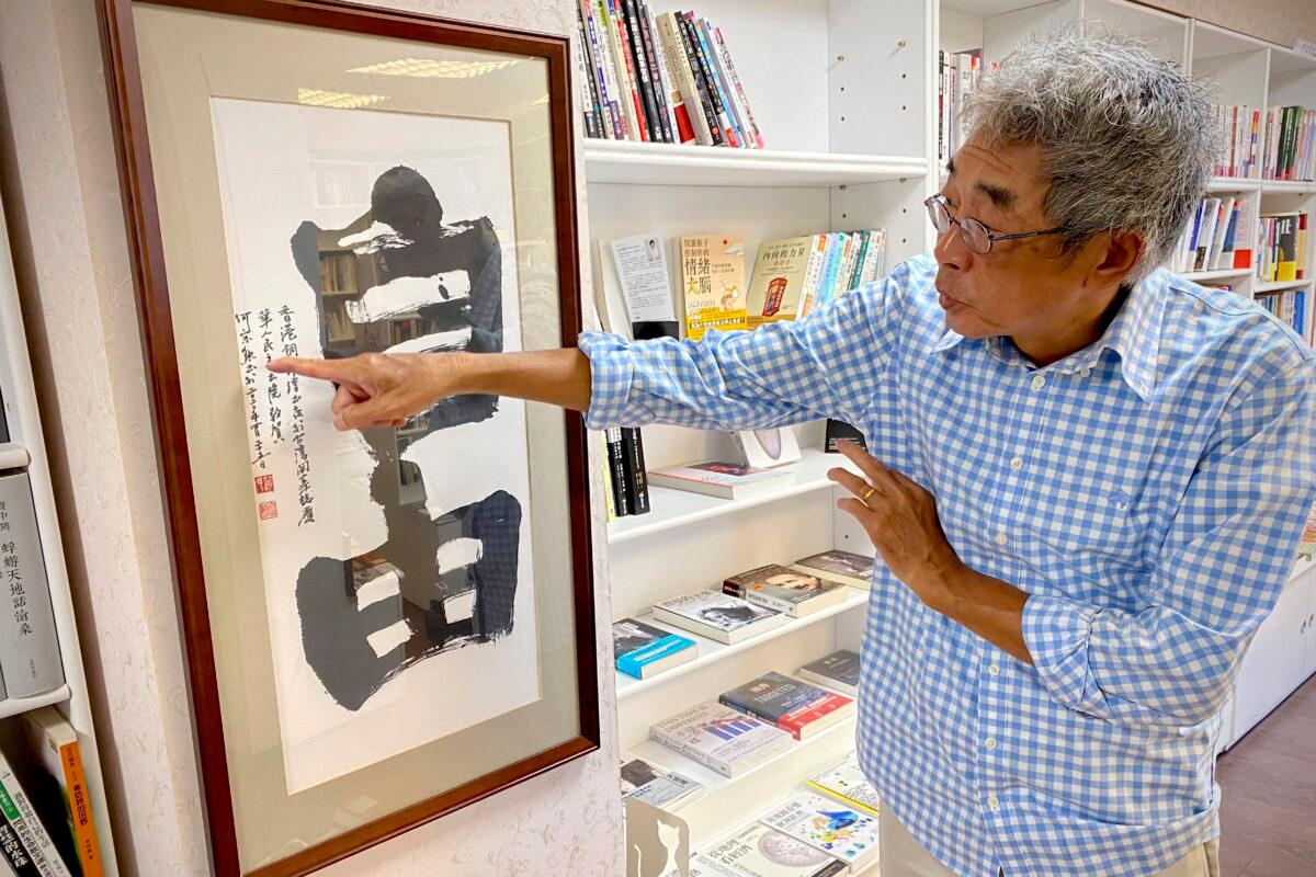 Lam Wing-Kee, a Hong Kong bookstore owner who fled to Taiwan in 2019, gestures at a calligraphy with the words "Freedom" during an interview inside his bookstore in Taipei, Taiwan, on June 8, 2022. (Johnson Lai/AP Photo)