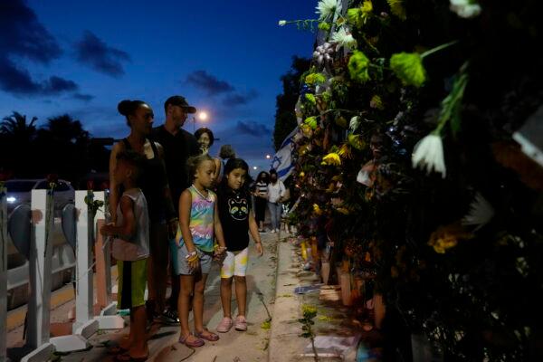 Well-wishers visit a makeshift memorial for the victims of the Champlain Towers South condo building collapse, as they gather for a multi-faith vigil near the site where the building once stood, in Surfside, Fla., on July 15, 2021. (Rebecca Blackwell/AP Photo)