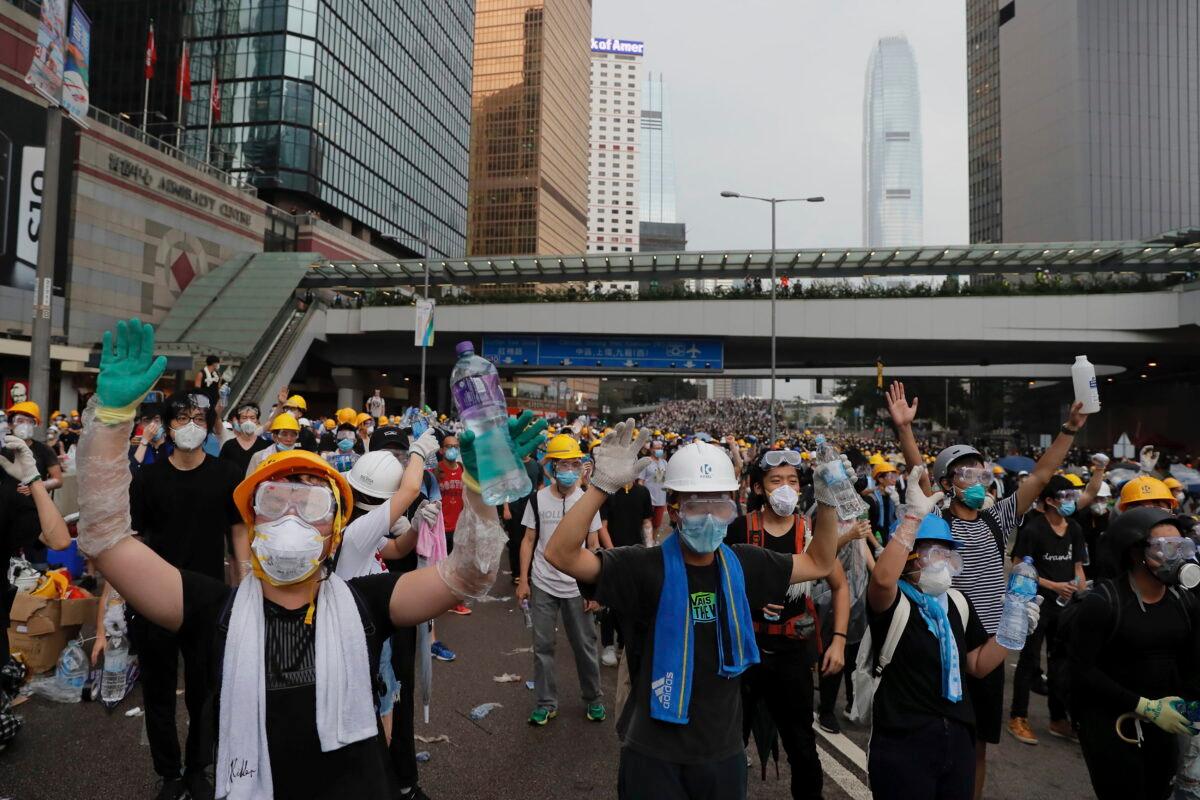 Protesters gesture to riot police during a massive demonstration outside the Legislative Council in Hong Kong on June 12, 2019. (Kin Cheung/AP Photo)