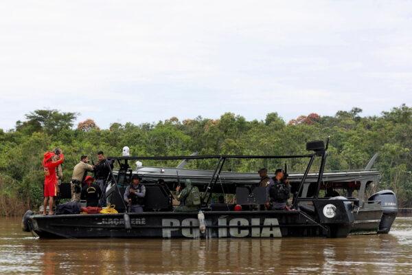 Police officers and rescue team members stand on a boat during the search operation for British journalist Dom Phillips and indigenous expert Bruno Pereira, who went missing while reporting in a remote and lawless part of the Amazon rainforest, near the border with Peru, in Atalaia do Norte, Amazonas state, Brazil, on June 12, 2022. (Bruno Kelly/Reuters)