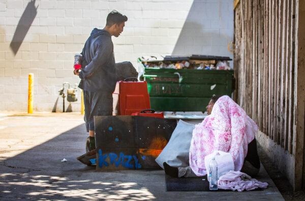 Homeless individuals chat together in Santa Ana, Calif., on June 28, 2022. (John Fredricks/The Epoch Times)