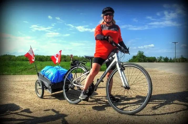 Cara McMinn poses for a photo during her two-month cross-Canada bike tour, dubbed “Tell Your Story: Memorial Ride,” to raise awareness of vaccine deaths and injuries, in Richer, Manitoba, on June 13, 2022. McMinn departed from Courtenay, B.C., on April 26 and expects to arrive in Ottawa on July 16. (Eldon Zigarlick)