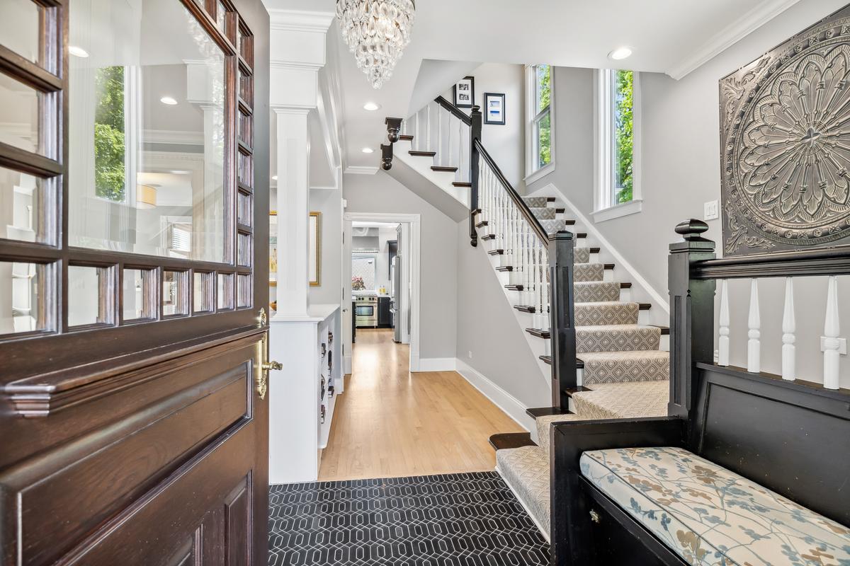 On first entering the home, you're greeted by the restored grand staircase, the gleaming, expansive hardwood floors, and other tasteful accents. (Courtesy of Baird & Warner)