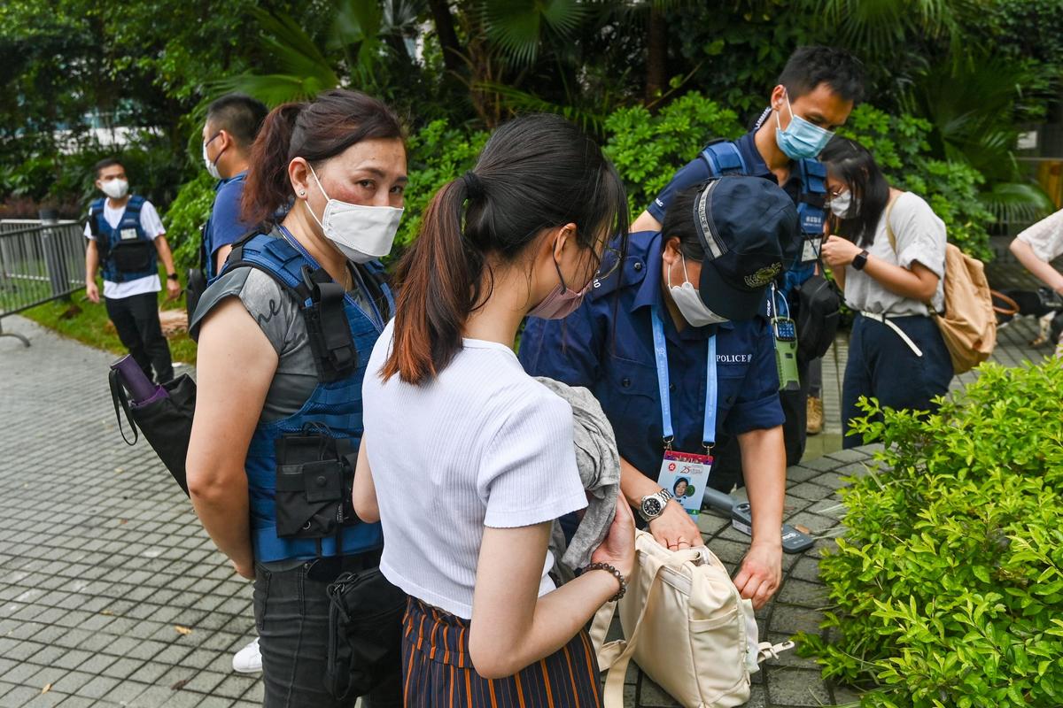 Hong Kong Police search a journalist’s bag. (Yu Gang/The Epoch Times)