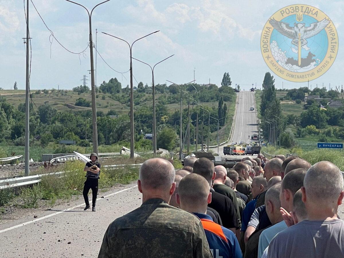 A man with a white flag walks on a road during an exchange of prisoners in the location given as Zaporizhzhia, Ukraine, in this handout photo released on June 29, 2022. (Courtesy of Ukraine's Military Intelligence/Handout via Reuters)