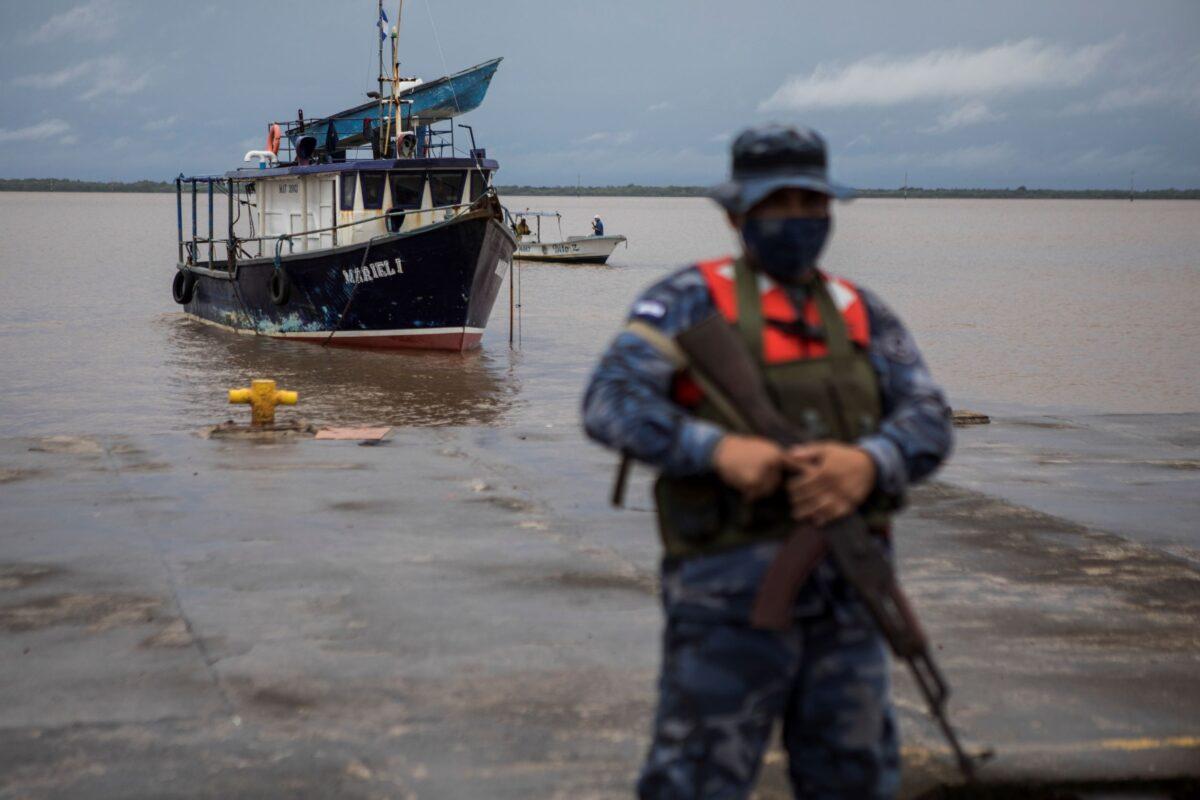 A Navy soldier stands guard as authorities wait for the arrival of people who were evacuated from the Monkey Point community, at the port in Bluefields, Nicaragua, on July 1, 2022. (Inti Ocon/AP Photo)