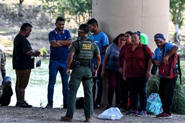 Illegal migrants are apprehended by U.S. Border Patrol and National Guard troops in Eagle Pass, Texas, near the border with Mexico on June 30, 2022. (Chandan Khanna/AFP via Getty Images)