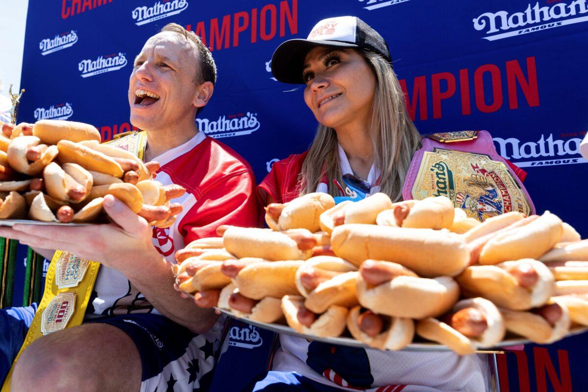 Joey Chestnut (L) and Miki Sudo pose with 63 and 40 hot dogs, respectively, after winning the Nathan's Famous Fourth of July hot dog eating contest in Coney Island, New York, on July 4, 2022. (Julia Nikhinson/AP Photo)