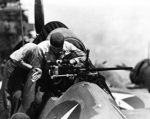 A crewmember inspects the .30 caliber twin Browning M1919 machine gun of a Navy scout bomber, 1942. (Public domain)