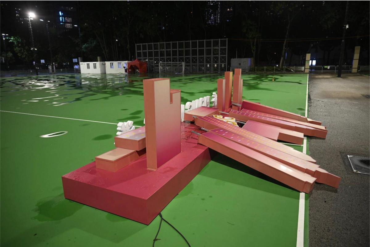 In the evening of July 1, 2022, a number of the exhibits in Victoria Park celebrating the 25th anniversary of the handover of Hong Kong were blown down, leaving only the banner with words "Hong Kong," lying on the pedestal. (Yan Wu/The Epoch Times)