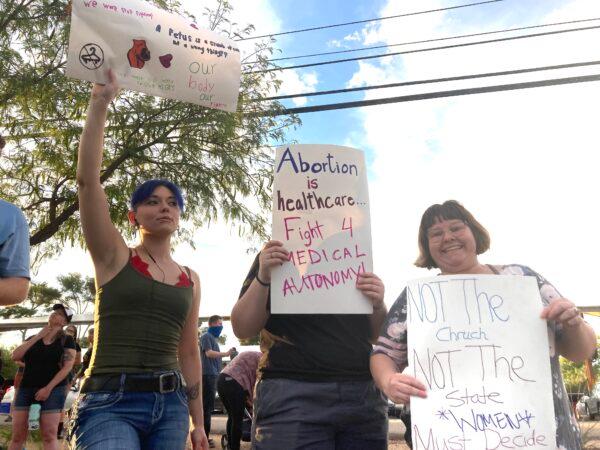 Protesters hold signs supporting abortion rights at a Women's March held in Tucson, Ariz., on July 4, 2022. (Allan Stein/The Epoch Times)