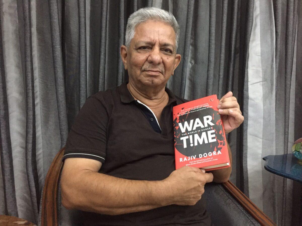 Rajiv Dogra, a former senior Indian diplomat and award-winning author, with his new book, "WARTIME: The World in Danger," in New Delhi on June 28, 2022. (Venus Upadhayaya/The Epoch Times)