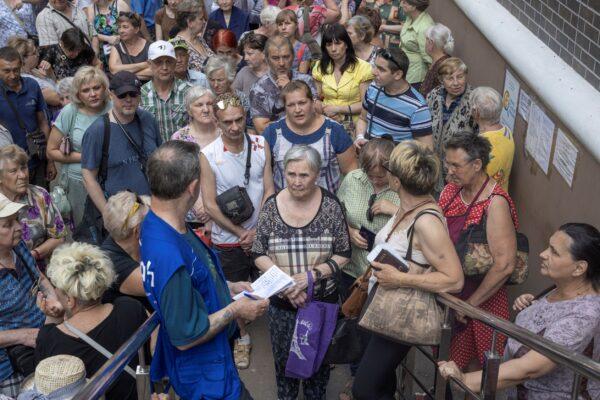 People wait to receive humanitarian aid in Kramatorsk, Donetsk region, Ukraine, on July 4, 2022. (Marko Djurica/Reuters)