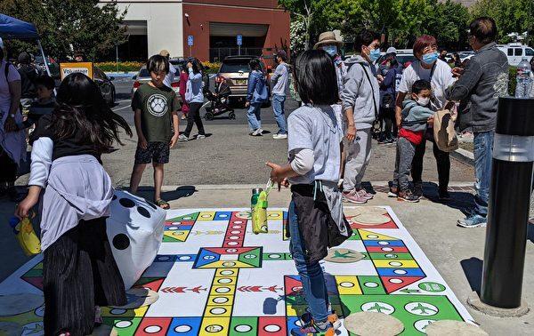 Children participated in the Hong Kong Carnival and played a large-scale "Chinese classic board game: Aeroplane Chess." (Emma Hsu/The Epoch Times)