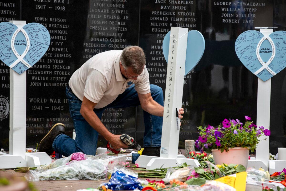A member of the Lutheran Church Charities assembles a memorial for the victims of a mass shooting at a Fourth of July parade, in Highland Park, Ill., on July 6, 2022. (Jim Vondruska/Getty Images)