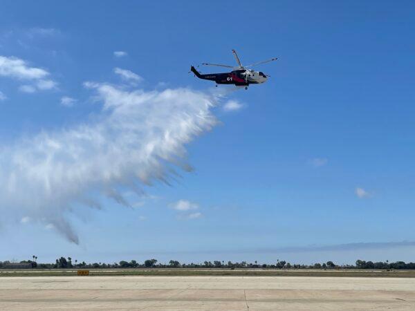 A fire-fighting helicopter water-dropping demonstration was attended by local fire officials at a news conference on the Quick Reaction Force, a firefighting effort funded by Southern California Edison, in Los Alamitos, Calif., on July 5, 2022. (Carol Cassis/The Epoch Times)