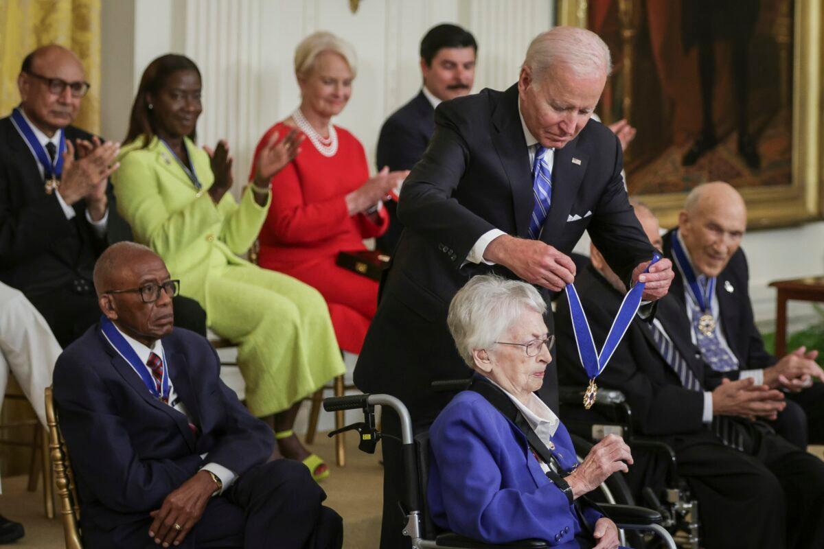 President Joe Biden presents the Presidential Medal of Freedom to retired Air Force Brig. Gen. Wilma Vaught, as other awardees clap, during a ceremony at the White House in Washington on July 7, 2022. (Alex Wong/Getty Images)