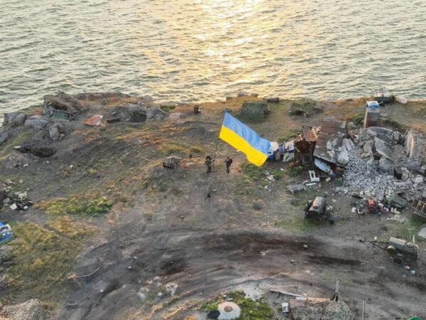 Ukrainian service members install a national flag on Snake (Zmiinyi) Island in the Odesa region, Ukraine, in this handout picture released on July 7, 2022. (Press service of the Ukrainian Armed Forces/Handout via Reuters)