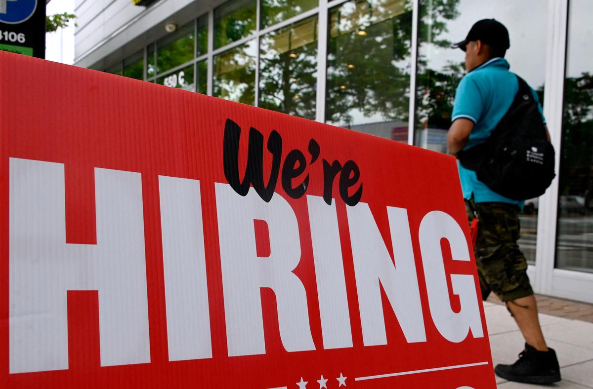 A man walks past a "now hiring" sign posted outside of a restaurant in Arlington, Va., on June 3, 2022. (Olivier Douliery/AFP via Getty Images)