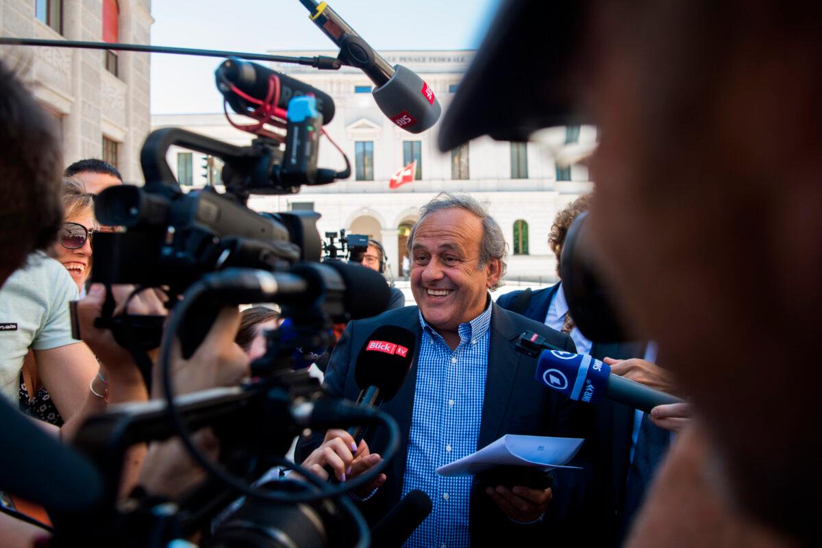 Former president of the Union of the European Football Association (UEFA) Michel Platini (C), surrounded by media representatives, speaks to the press in front of the Swiss Federal Criminal Court, on the last day of the trial, after the verdict was announced in Bellinzona, Switzerland, on July 8, 2022. (Ti-Press/Alessandro Crinari/Keystone via AP)